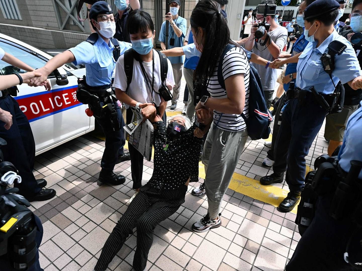 Aktivisten Alexandra Wong, der også er kendt som Bedstemor Wong, slæbes væk af politiet uden for den domstol, der lørdag besluttede at forlænge varetægtsfængslingen for to af de fem mediechefer, der blev anholdt i Hongkong torsdag. | Foto: PETER PARKS/AFP / AFP